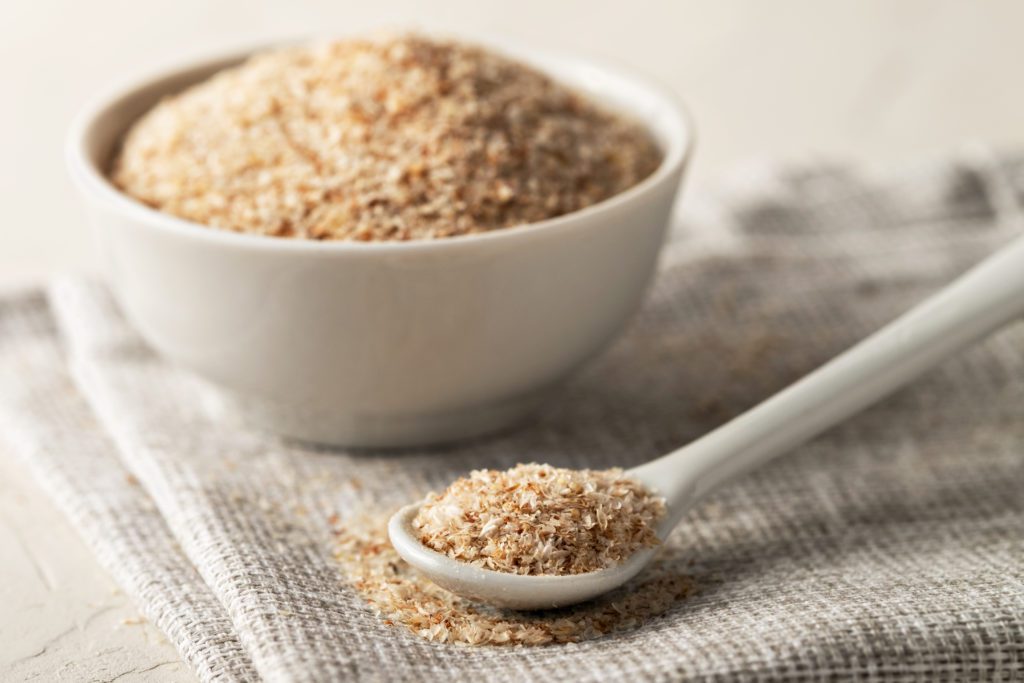 A pile of psyllium husks in a spoon and bowl on the table