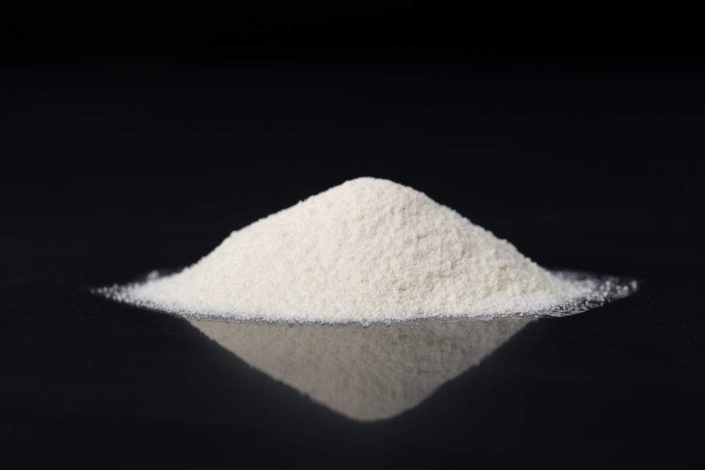 Mound of glucosamine powder on a black background